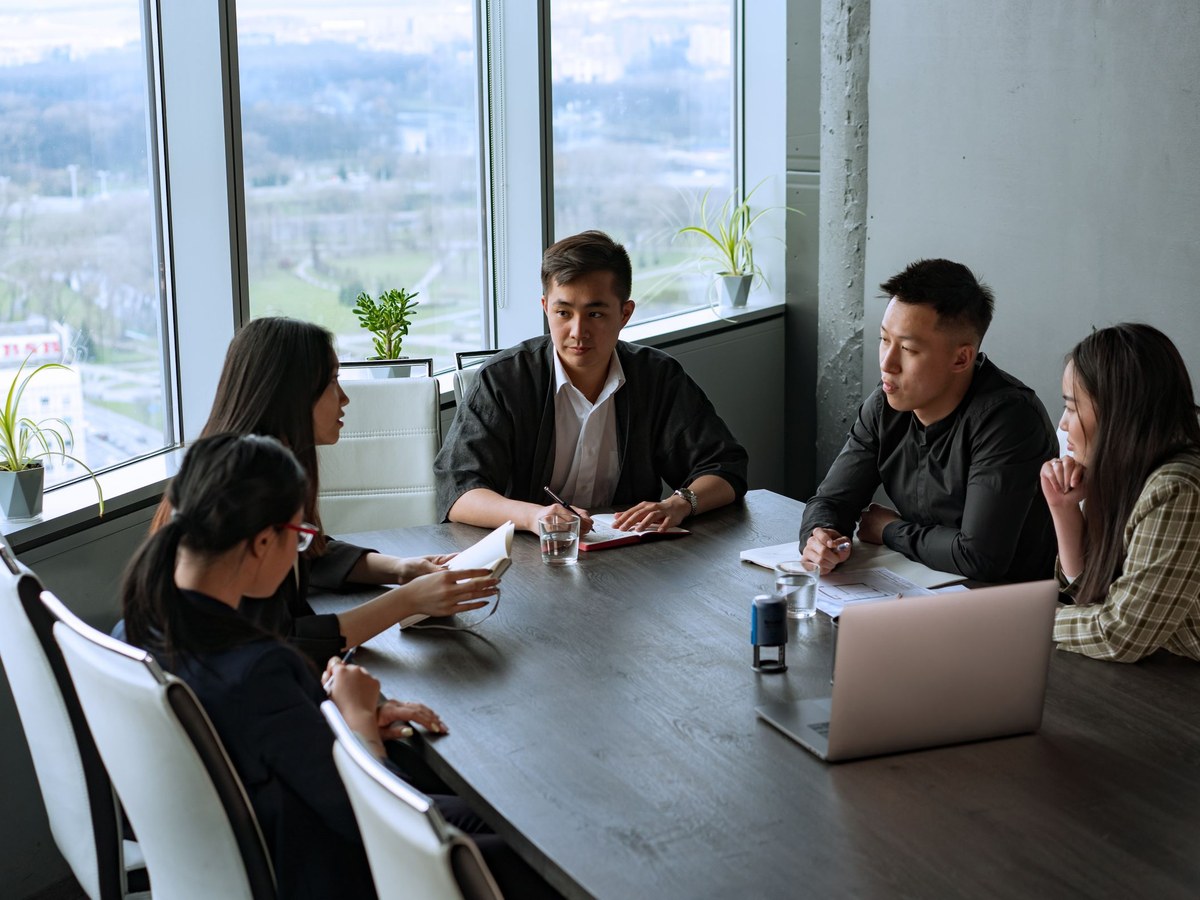 Team discussing a project around a table by a window